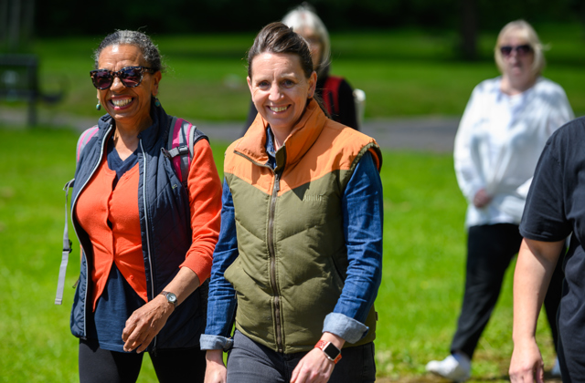 Two women on a walk whilst smiling at the camera